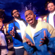 Image of R&B group All-4-One in colorful tracksuits singing "It's All There" in front of a fountain.